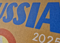 Text 'RUSSIA 2025' printed on a textured surface with a brown background.