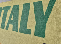 Text 'ITALY' printed on a textured green surface