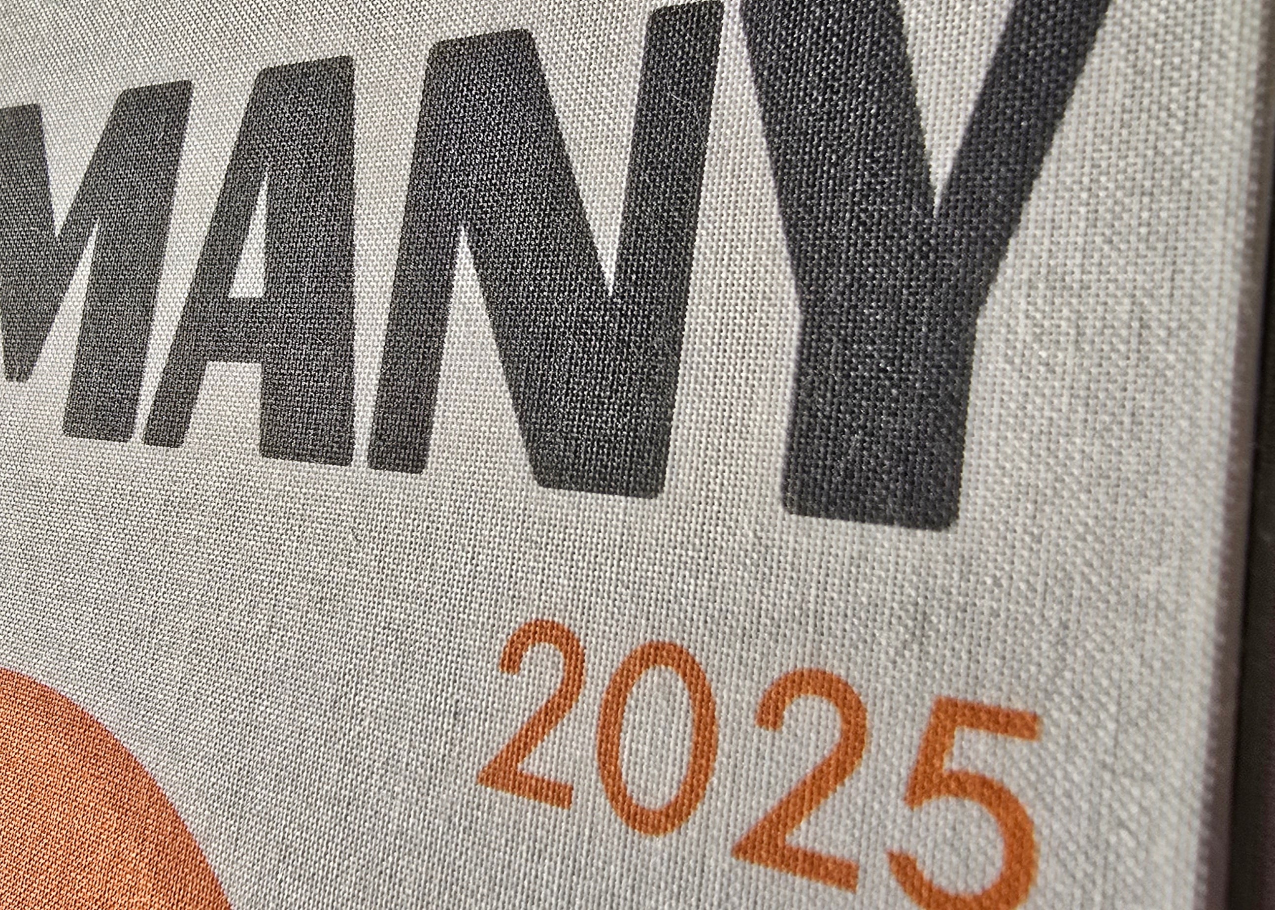 Text 'GERMANY 2025' on a textured surface with a colorful design.