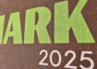 Brown bag with 'DENMARK 2025' printed in green and white text.
