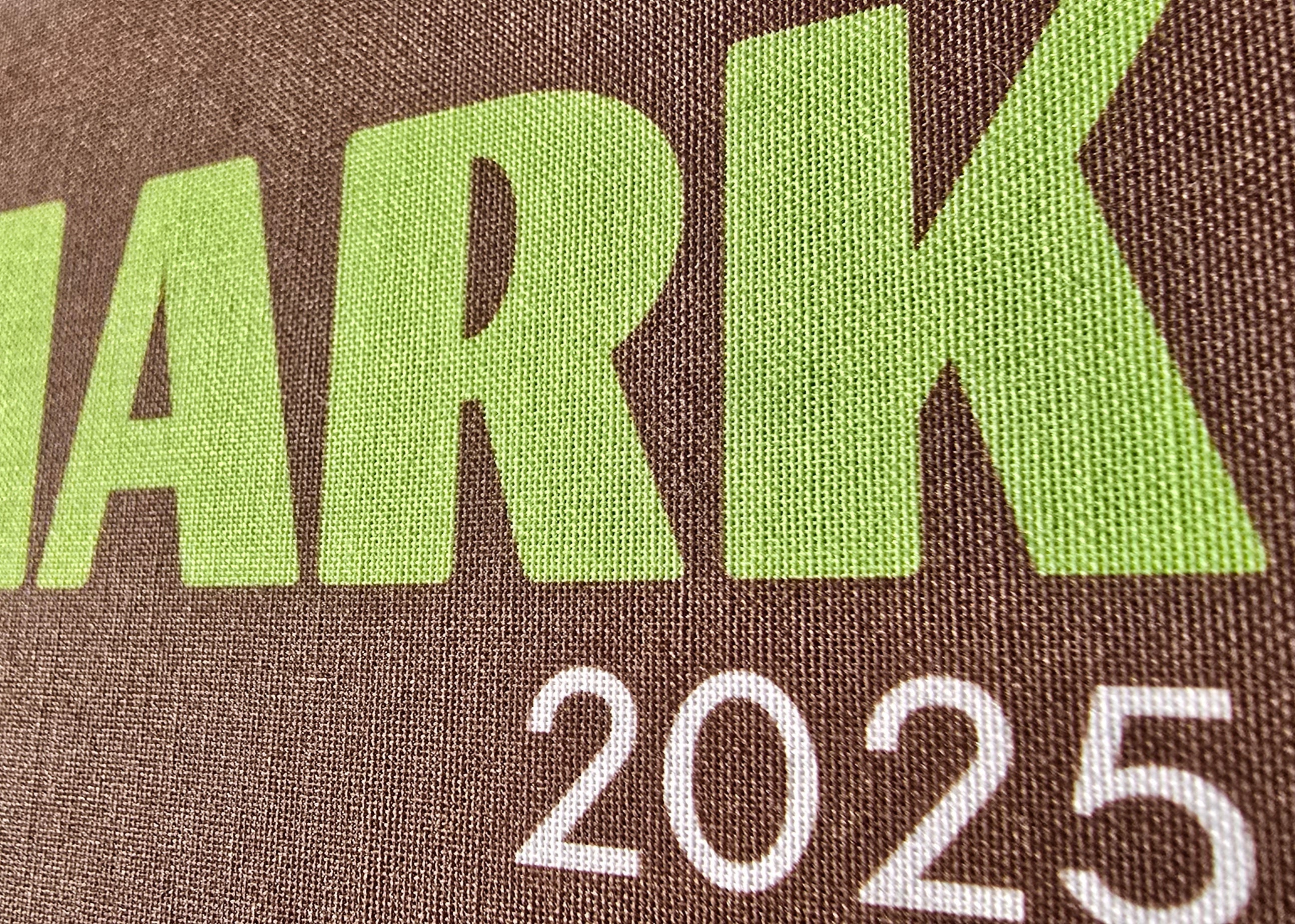 Brown bag with 'DENMARK 2025' printed in green and white text.