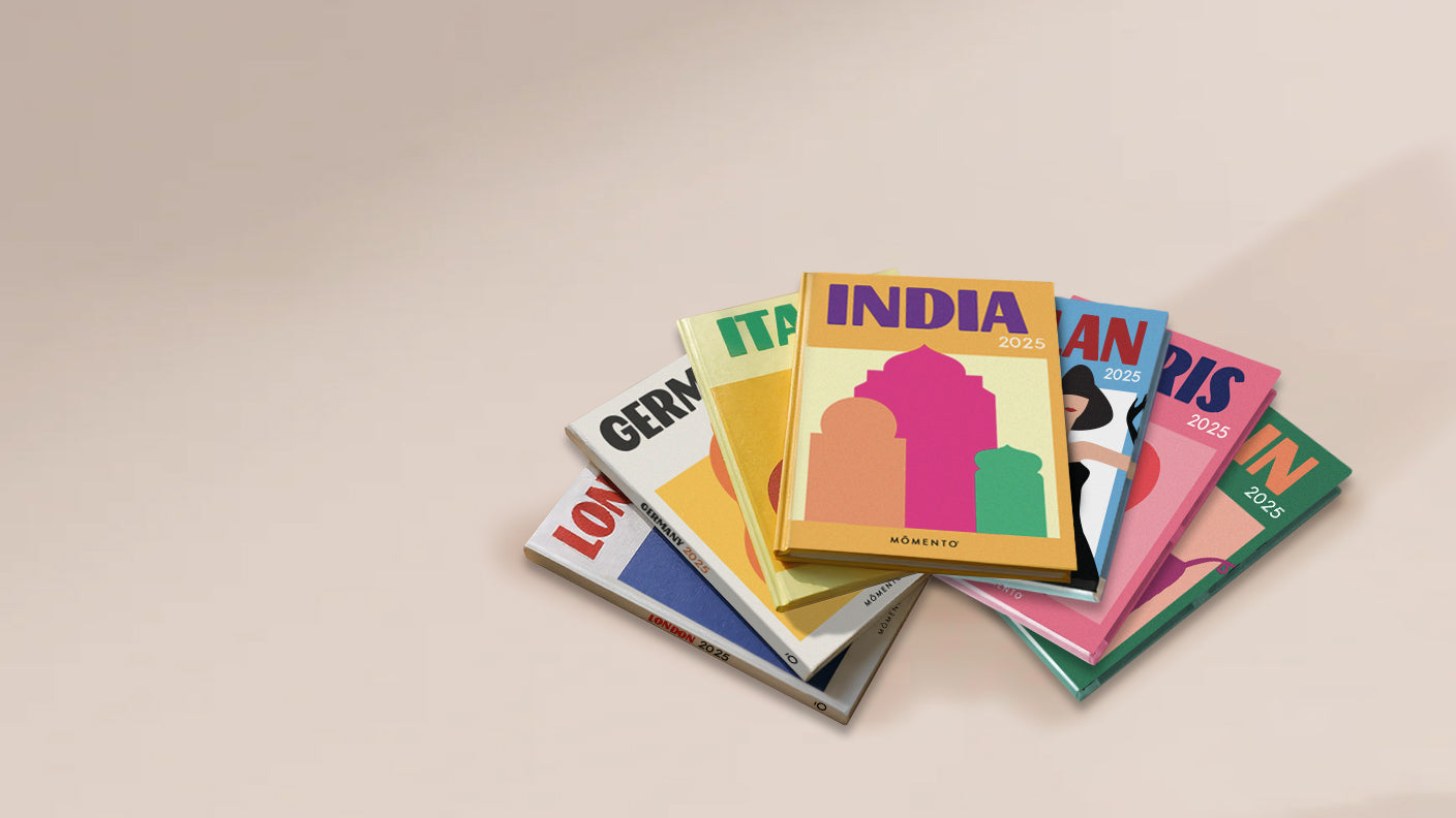 Stack of colorful travel guide books on a beige background